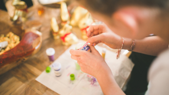 Picture of hands making a craft with supplies around